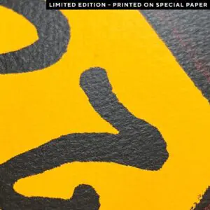 Gros plan de lignes abstraites noires et audacieuses sur une surface jaune texturée. Une étiquette en haut de la page indique "ÉDITION LIMITÉE - IMPRIMÉ SUR PAPIER SPÉCIAL" en texte blanc sur fond noir.