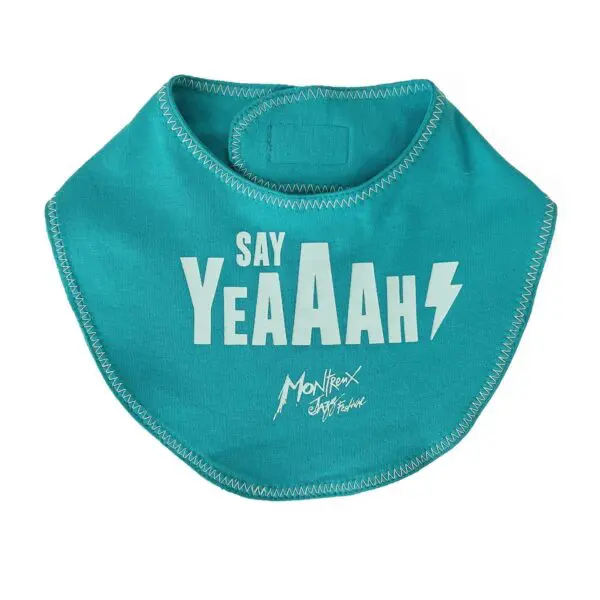 Le Bavoir Baby Say Yeaaah ! est un bavoir sarcelle avec des coutures blanches en zigzag, un texte en gras "SAY YeAAAH", un éclair et "Montreux Jazz Festival" dans une écriture élégante en dessous.