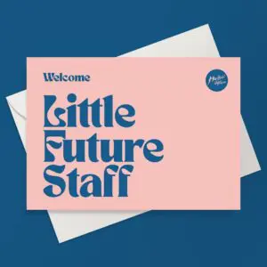 MJF23-Carte-de-voeux-mockup-LittleFutureStaff-1.jpg La Carte de vœux du Petit Personnel d'Avenir est une carte rose avec un texte bleu en gras indiquant "Bienvenue au Petit Personnel d'Avenir", placée sur une enveloppe blanche sur fond bleu, parfaite pour célébrer le prochain Festival du Petit Personnel d'Avenir.