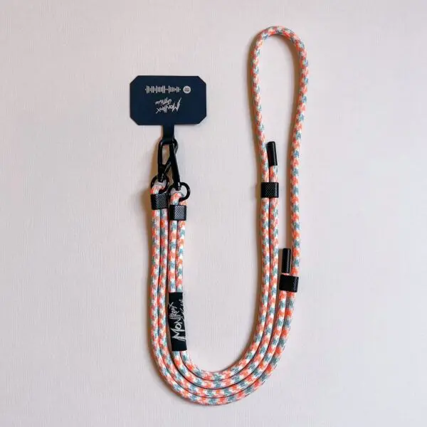 A vibrant rope-style dog leash with orange, white, and teal patterns—attached to a black clip and branded dark tag—laid on a light surface, inspired by the Mobile Strap, Lakeside design.