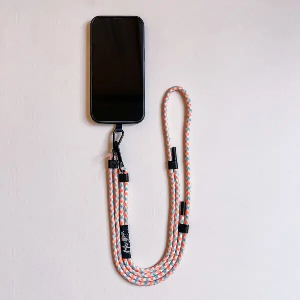 A smartphone with a Mobile Strap, Lakeside lanyard featuring vibrant orange, white, and blue colors with a metal clip, laid flat on a light surface.