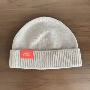 Un bonnet en tricot avec une étiquette rouge.