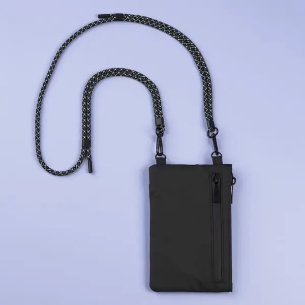 A compact black Festival Bag, Lakeside, with a zippered front pocket and detachable black-and-white rope strap, shown on a light purple background.