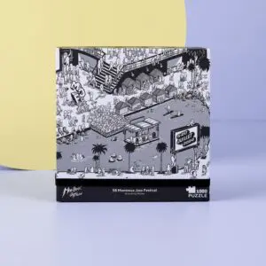 Une boîte de puzzle de 1000 pièces présente une illustration en noir et blanc d'une foule animée au 58e Festival de jazz de Montreux, avec une scène, des tentes, des palmiers et 2024 Juillet 5-20 sur un panneau dans la scène.