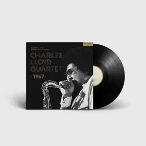 Un disque vinyle partiellement sorti de sa pochette, sur laquelle figure une photo en noir et blanc de Charles Lloyd jouant du saxophone. Sur la pochette, on peut lire : "Charles Lloyd Quartet, Live at Montreux Jazz Festival, 1967" : Charles Lloyd Quartet, Live at Montreux Jazz Festival, 1967.