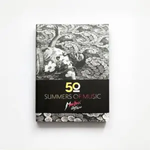 Le livre 50 Summers Of Music présente une couverture en noir et blanc montrant une personne allongée sur une surface à motifs, avec le logo du Montreux Jazz Festival sous le titre.