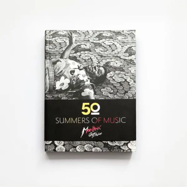Le livre 50 Summers Of Music présente une couverture en noir et blanc montrant une personne allongée sur une surface à motifs, avec le logo du Montreux Jazz Festival sous le titre.