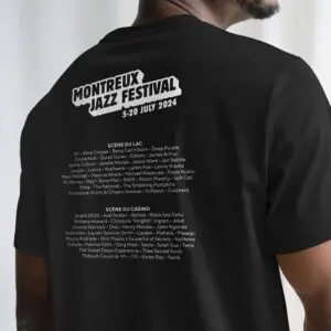 Quelqu'un porte l'édition limitée du T-Shirt Lineup 2024, avec un texte blanc au dos listant les artistes du Montreux Jazz Festival pour la période du 5 au 20 juillet 2024, divisé en deux sections de scène.